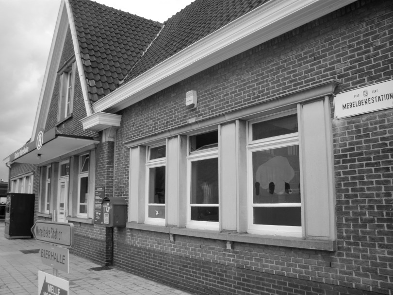 Voor de visuele afwisseling legde ik het betreffende gebouw ook vast in een liggend beeld. Waarbij mijn oog plots op een straatnaambordje viel, rechts op de foto.