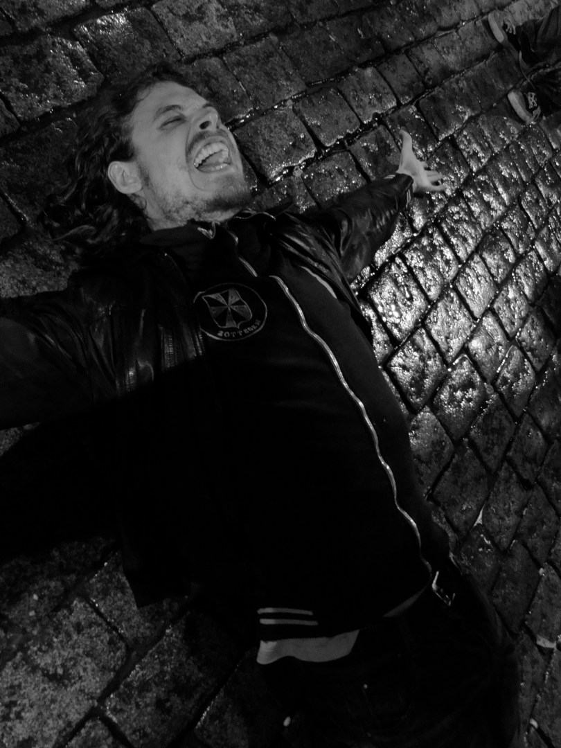 Een Gentse sjamaan Een jongeman probeert de Vlasmarkt te behoeden voor regen. Alvast een tiental kasseien bleef enige minuten droog onder zijn schrale leden.