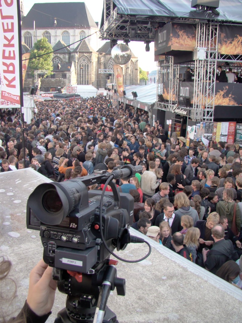 De Vlasmarkt om iets voor acht uur 's morgens, gezien van op het dak van de wc-cabine. Het volk is nog massaal aanwezig en wordt lustig gefilmd door cameralui van Hans Buyse.