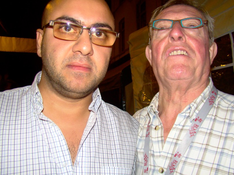 Nima zet een pokerface op terwijl de Ouwe Volkszanger in zijn oor staat te brullen en bewijst daarmee dat verdraagzaamheid van twéé kanten komt.